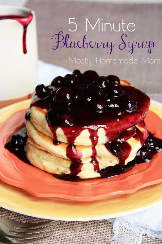 Blueberry syrup over a stack of pancakes on a plate