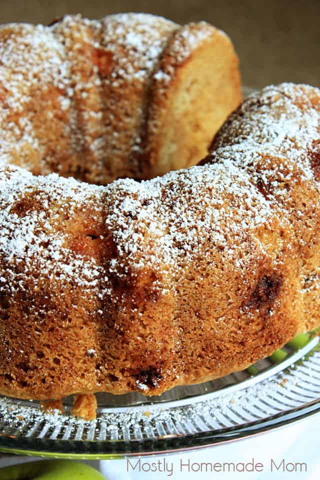 Apple Pound Cake dusted with powdered sugar on a glass cake plate