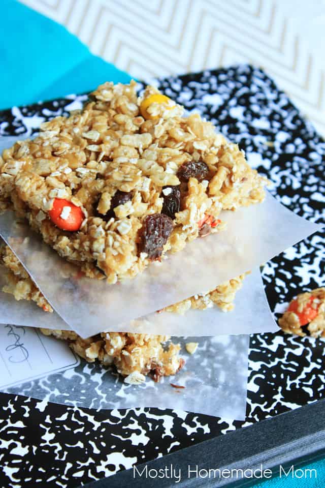 Rice Krispies granola bars stacked with wax paper on top of a notebook