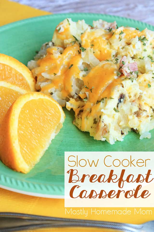 A piece of slow cooker breakfast casserole on a green plate next to some orange slices