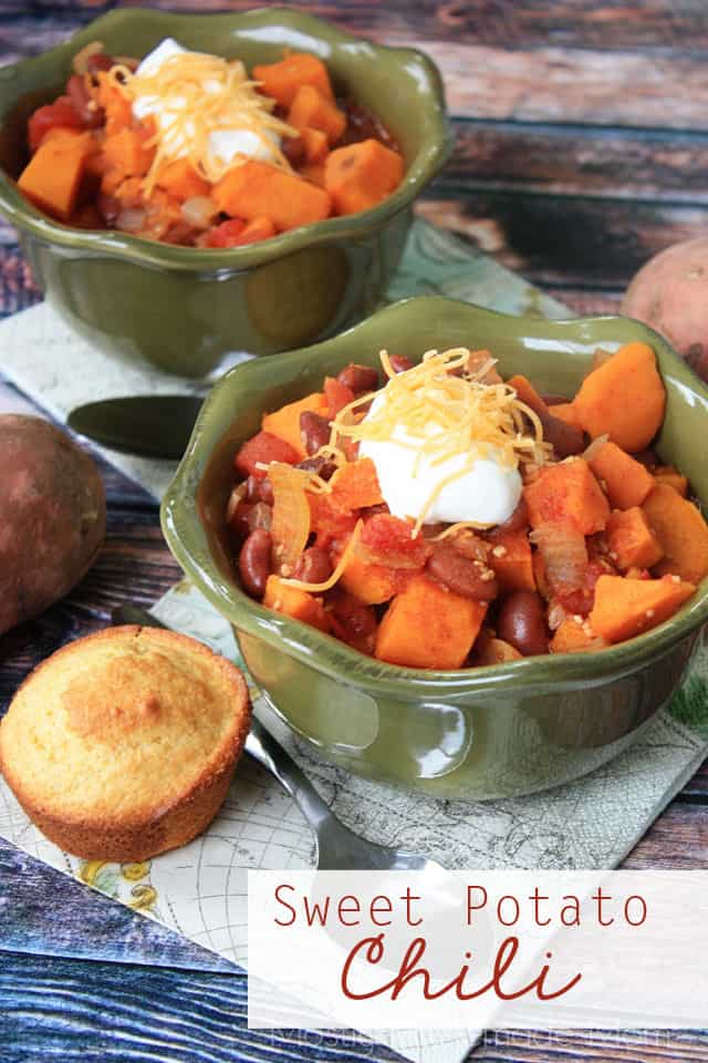 Two bowls of sweet potato chili with cornbread muffins next to them