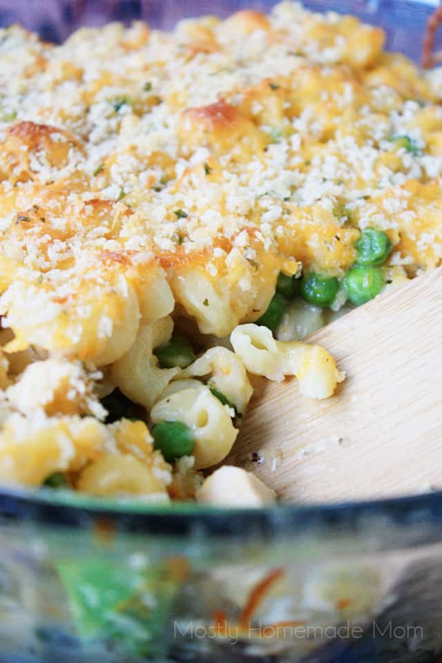 Chicken mac and cheese in a casserole dish with a wooden serving spoon