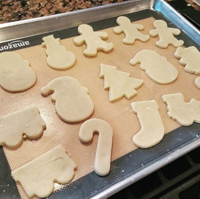 Cream cheese cutout cookies on a cookie sheet ready to be baked
