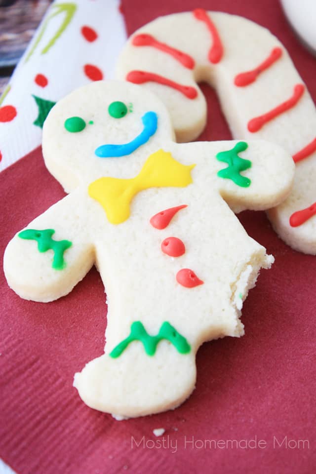A close up of a cream cheese cut out cookie gingerbread man with a bite taken out