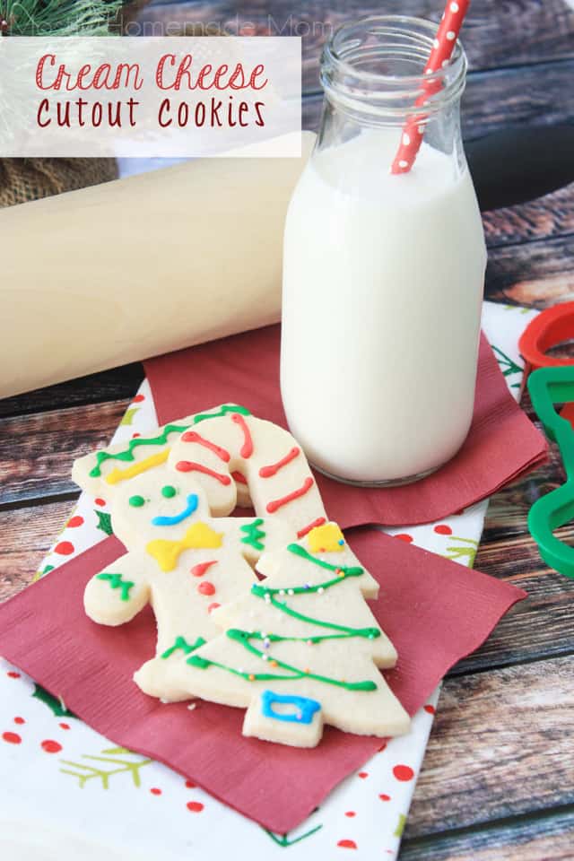 Decorated cream cheese cutout cookies next to a glass of milk