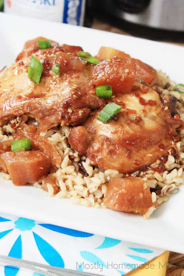 Crock Pot teriyaki chicken with pineapple over brown rice on a white plate