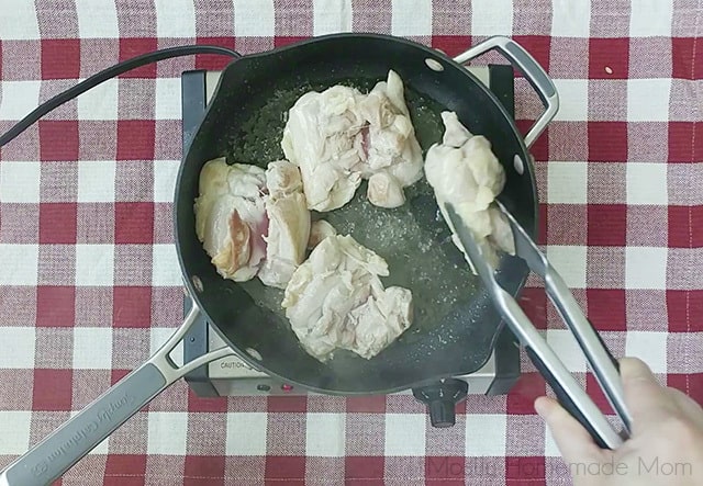 Boneless chicken thighs being cooked in a skillet