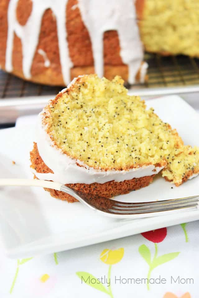 A slice of lemon poppy seed pound cake on a white plate with a fork