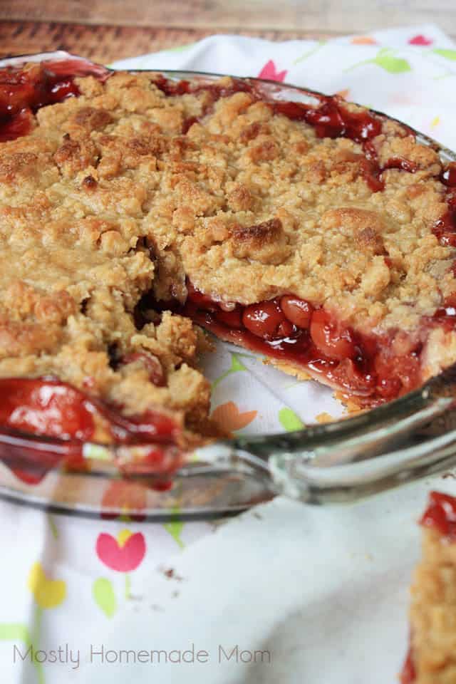 Glass pie plate with baked cherry crumb pie