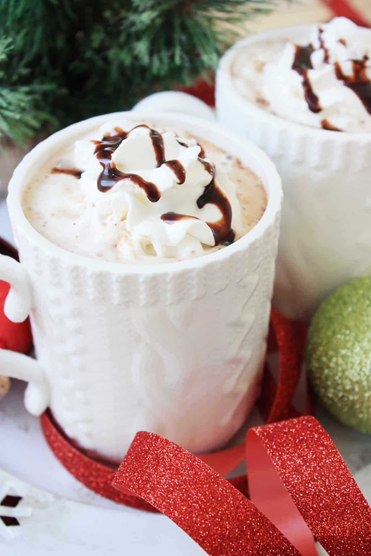 A white mug with eggnog hot chocolate.