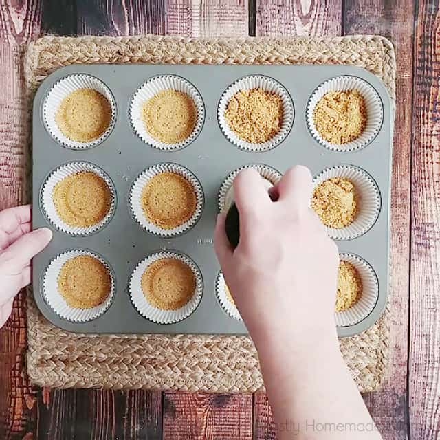 Adding crust mixture to muffin cups