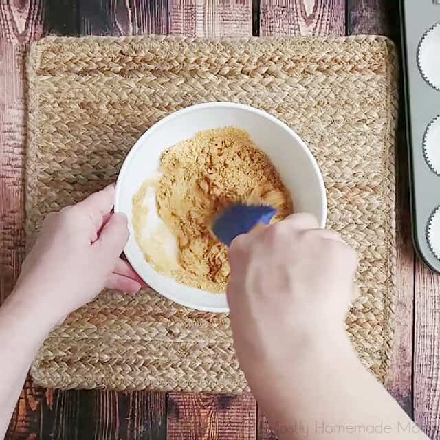 Mixing crust ingredients in a bowl with a spatula