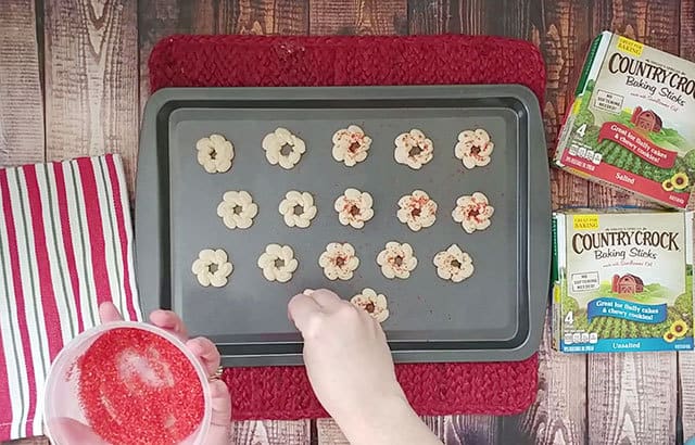 Decorating cookie dough with red sugar