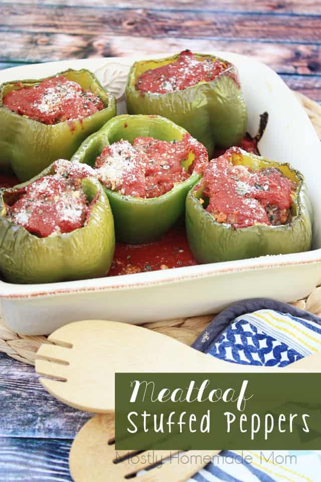 Meatloaf stuffed peppers in a baking dish with a wooden spoon next to it