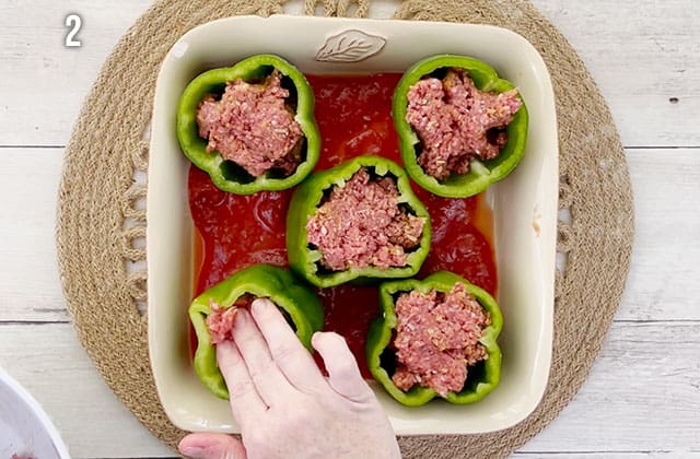 Stuffing green peppers with a meat mixture in a baking dish