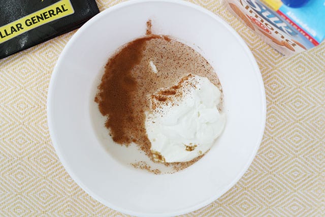 Greek yogurt, almond milk, brown sugar, and spices in a white mixing bowl