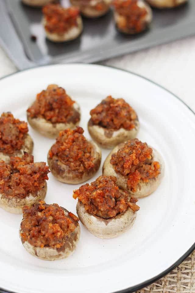 Sausage stuffed mushrooms on a white serving platter