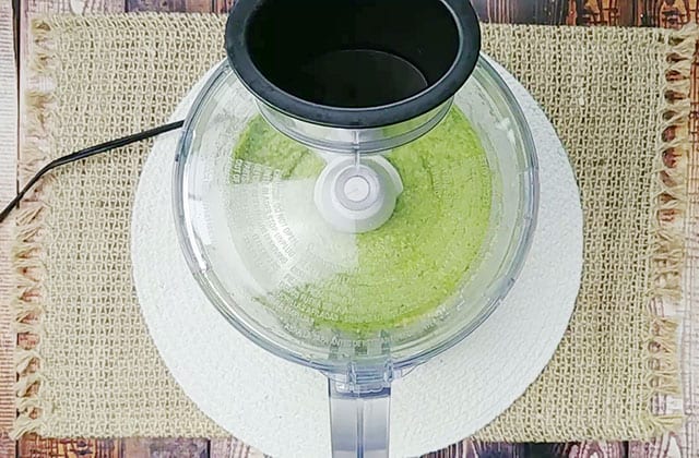 Spinach pesto being blended in a food processor