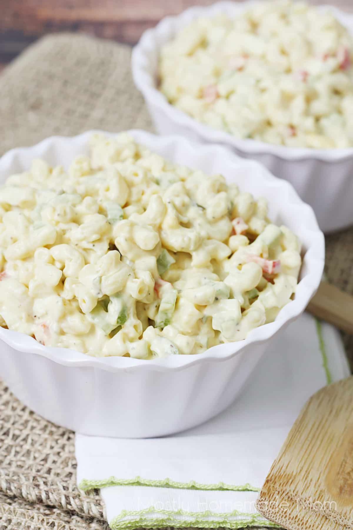 Two serving bowls filled with macaroni salad.