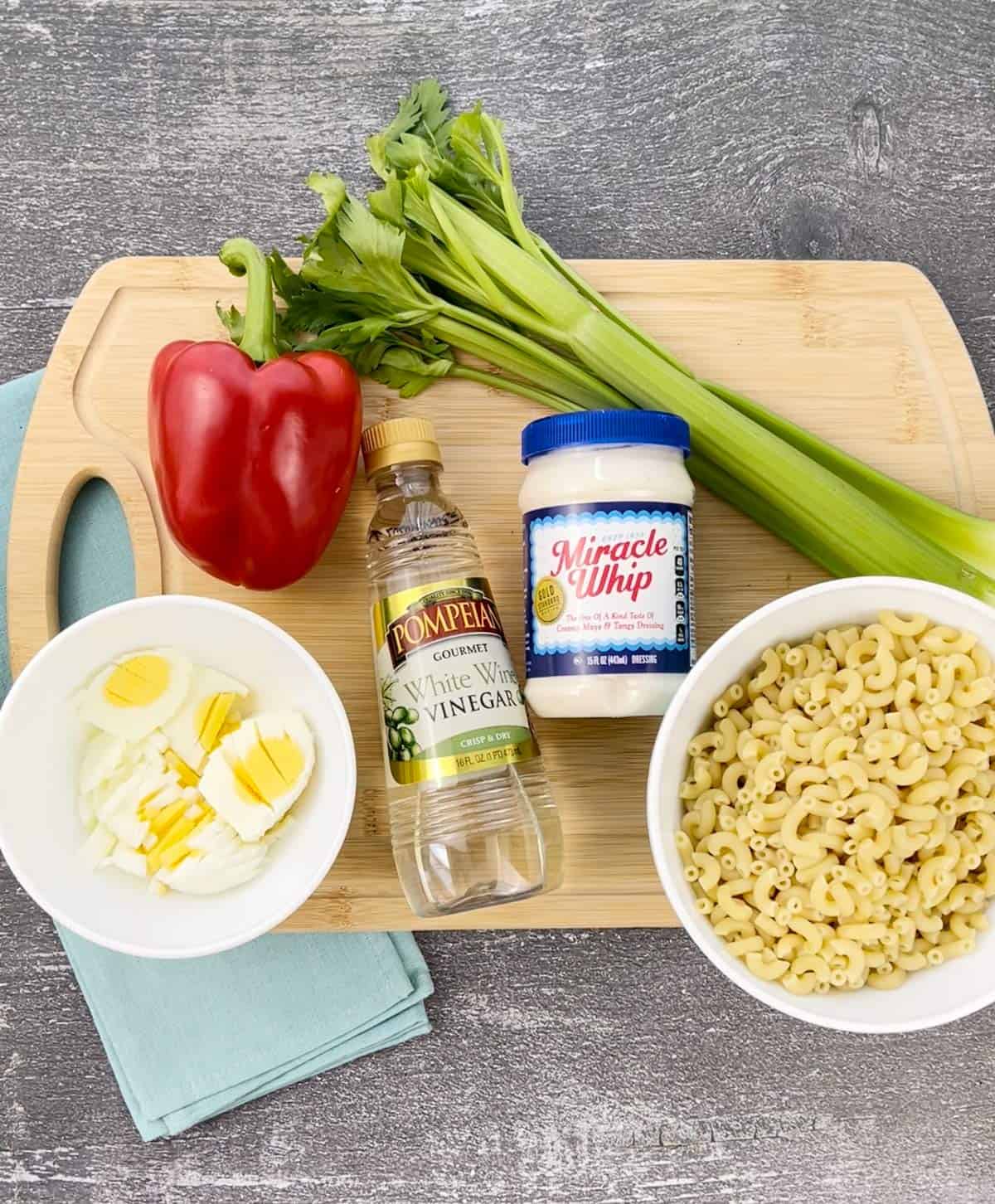 Ingredients for Amish macaroni salad on a cutting board.