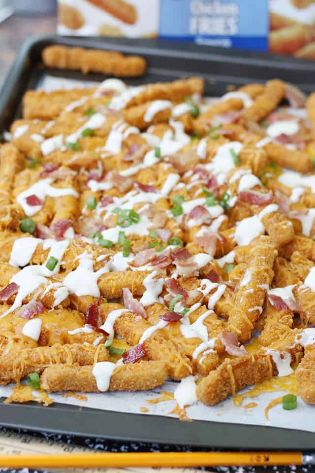 Loaded ranch chicken fries on a parchment lined baking sheet