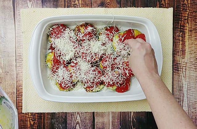 Sprinkling zucchini parmesan casserole with mozzarella cheese
