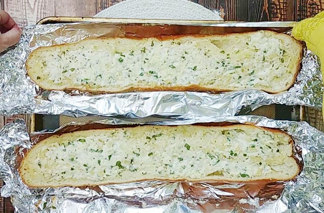 Homemade garlic bread loaves on foil on a baking sheet