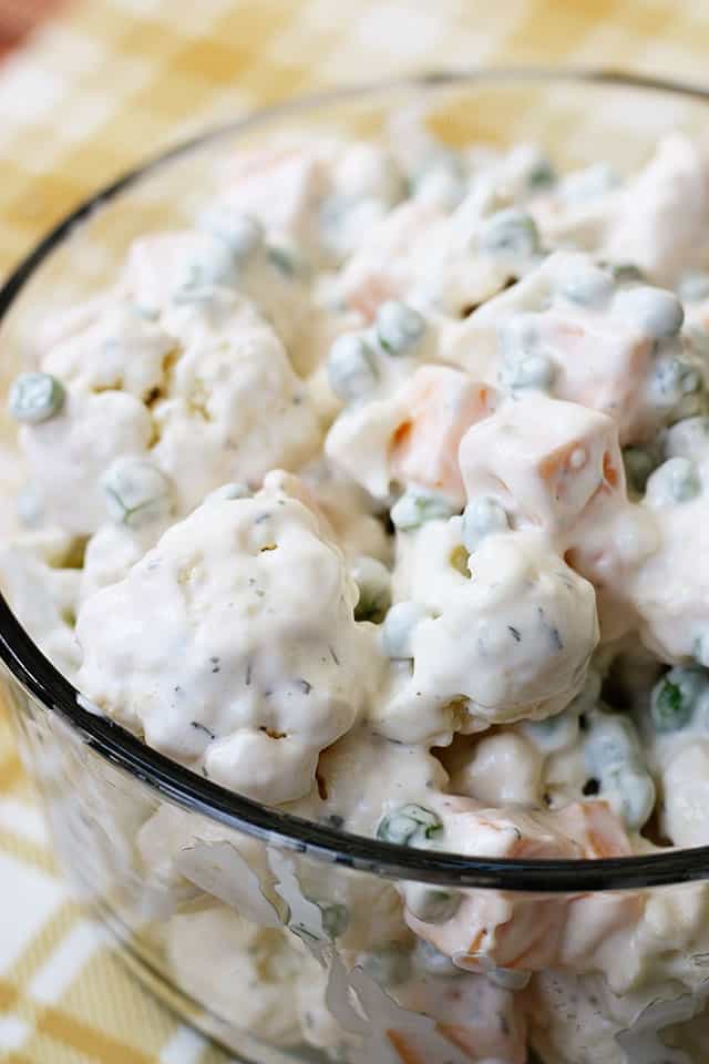 A close up picture of cauliflower salad in a glass mixing bowl
