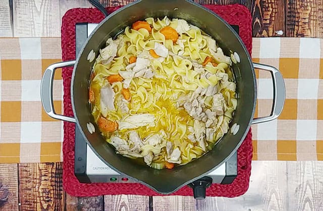 The Best chicken noodle soup recipe in a soup pot on a skillet