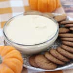 Pumpkin dip in a glass bowl with ginger snaps next to it