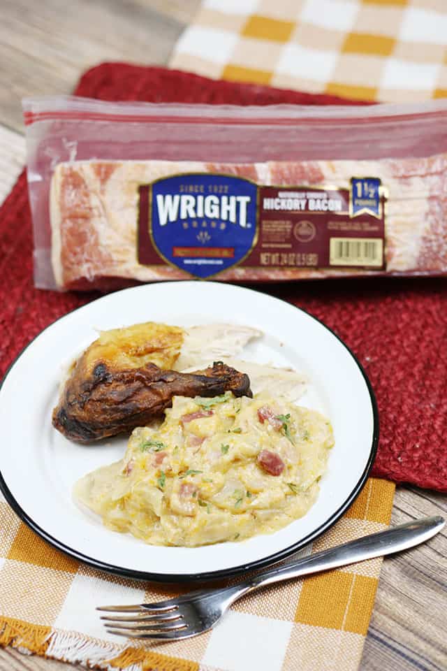 A plate of potatoes and chicken with Wright Bacon in the background