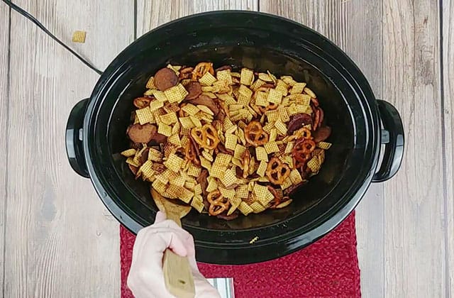 Stirring Crockpot Chex mix in a crockpot