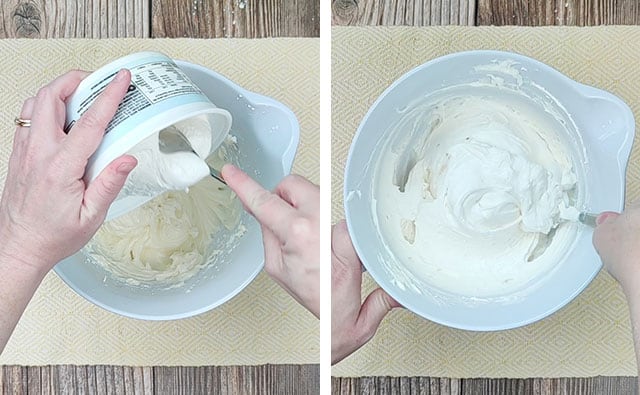 Mixing cool whip into the cheesecake mixture in a white mixing bowl
