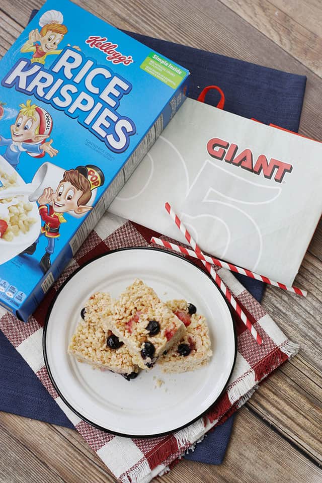 Berry rice krispie treats next to a box of cereal