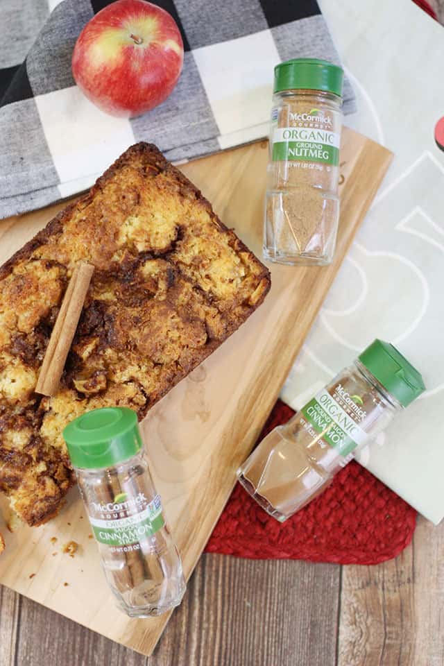 Cinnamon Apple Bread on a cutting board with glass seasoning jars