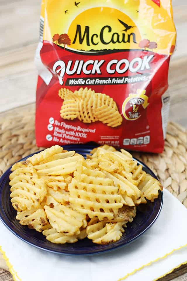 McCain Quick Cook Waffle Cut fries on a blue plate in front of the product bag