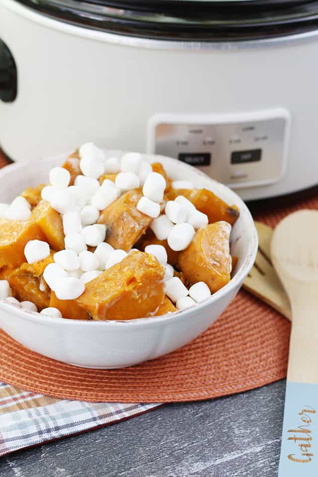 Crockpot sweet potato casserole in a white bowl in front of a white Crockpot